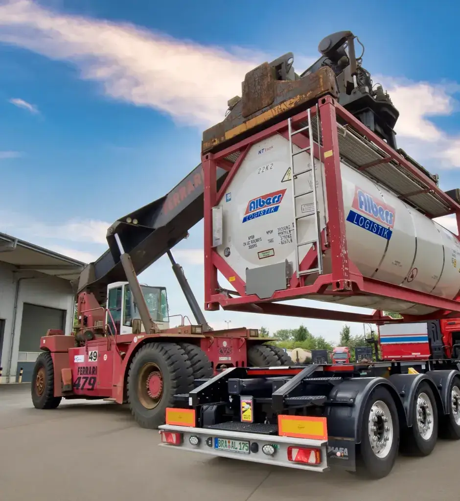 Reachstacker hebt einen Tankcontainer auf einen Sattelauflieger auf dem Gelände von Albers Logistik.